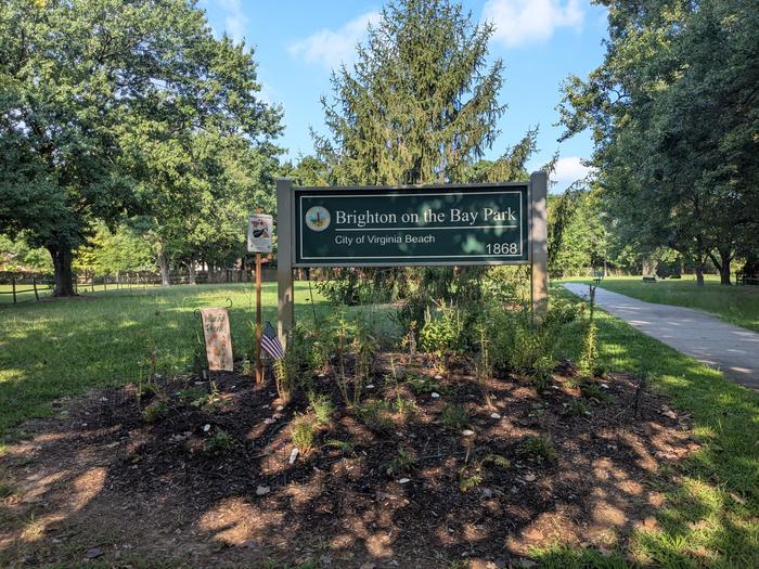 The Brighton on the Bay Park sign along a shaded walking path